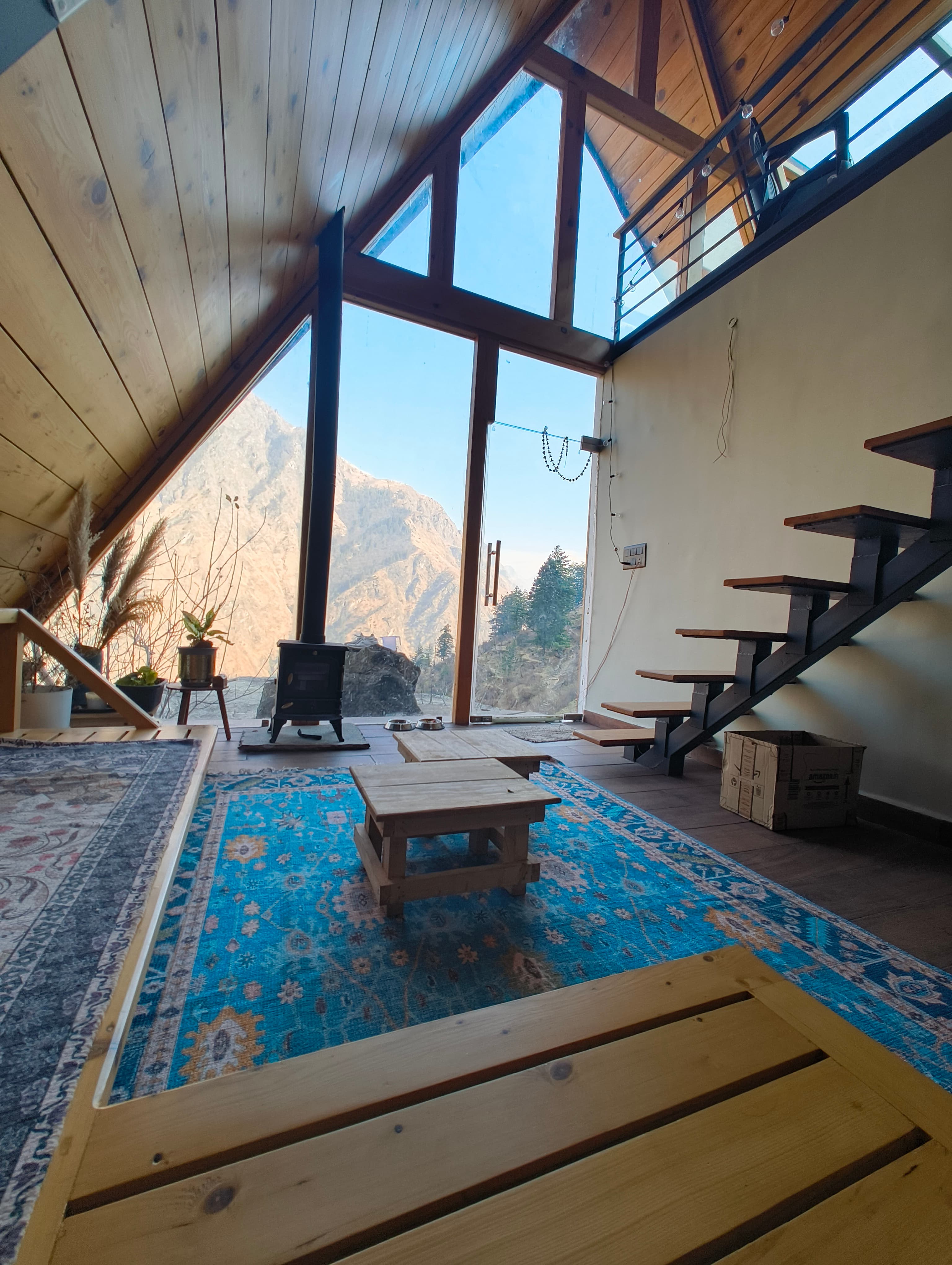 Shared living space at Vaadi — warm wood interiors with mountain light